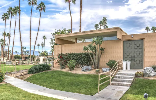 a front view of a house with a garden and plants