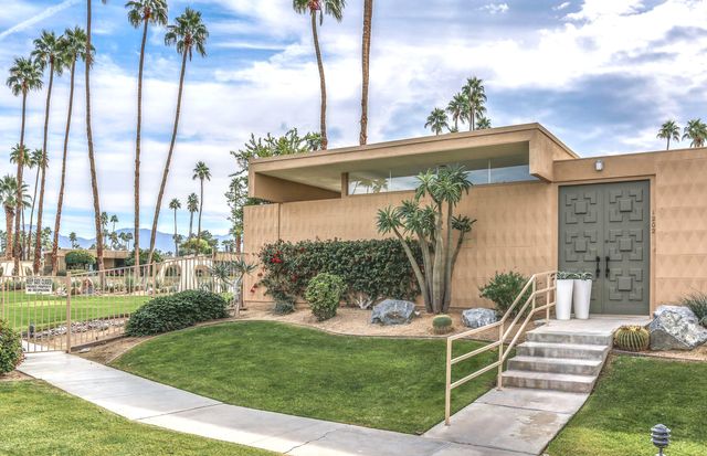 a front view of a house with a garden and plants