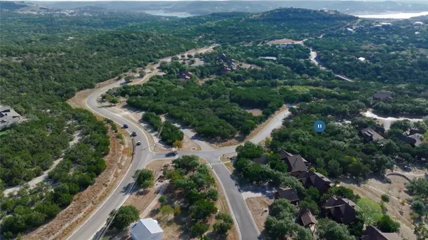 an aerial view of residential house with outdoor space and trees all around