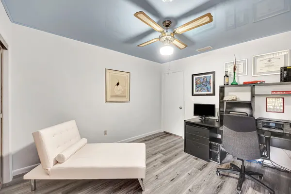 a room with furniture and a chandelier fan