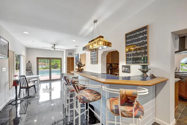 a kitchen with stainless steel appliances granite countertop a stove a sink a oven a dining table and chairs with wooden floor