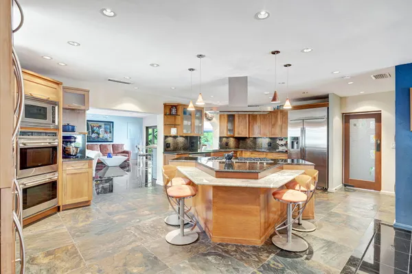 a kitchen with stainless steel appliances granite countertop a sink a stove and a refrigerator