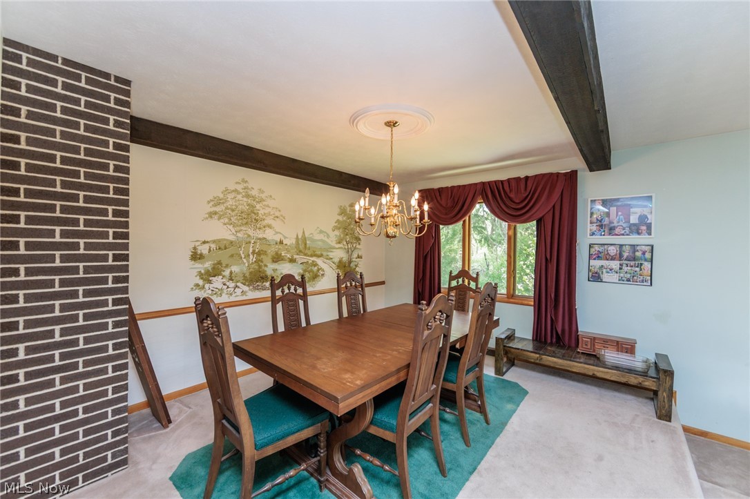 2170 Norton Road Stow, OH 44224 - Photo 29 of 48 Dining area featuring a brick architectural element, wood-finish ceiling beams, and a chandelier with a decorative ceiling medallion