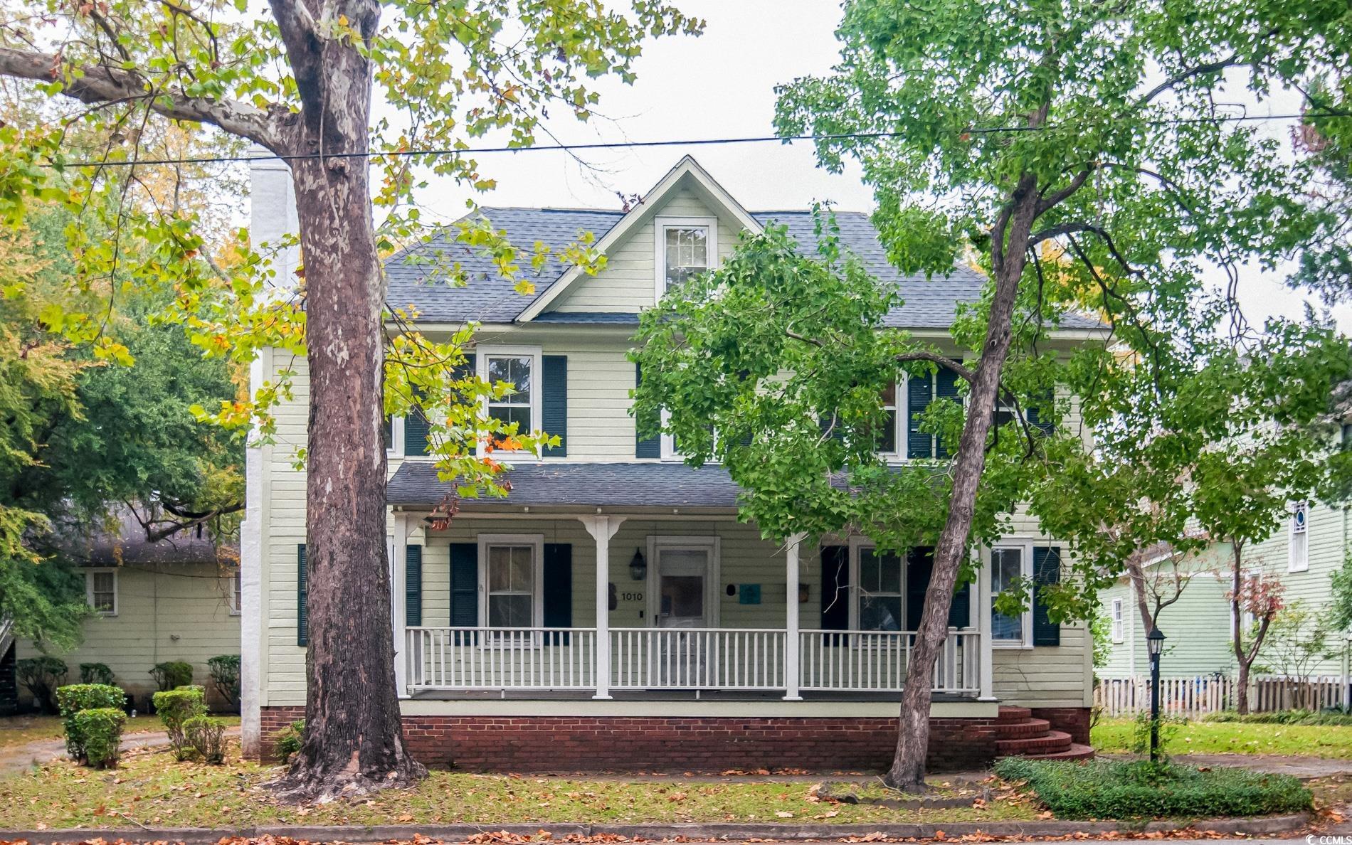 View of front of property with covered porch and a shingled roof