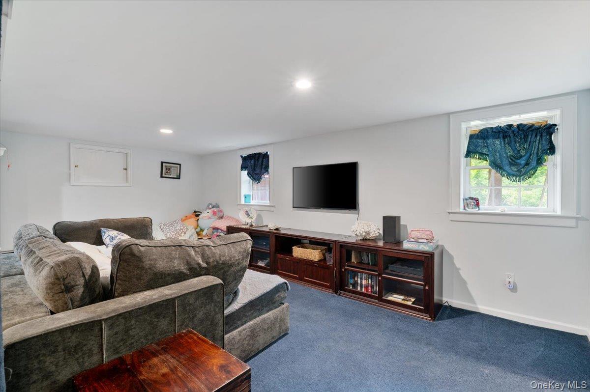 5 Fox Hunt Court Cold Spring Harbor, NY 11724 - Photo 24 of 42 Entertainment room featuring a built-in media console, recessed lighting, and a wall-mounted television