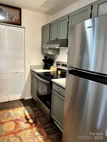 a kitchen with refrigerator and a stove