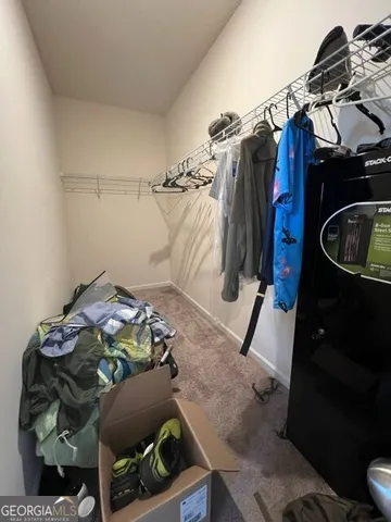 a view of walk in closet with clothes and shoes