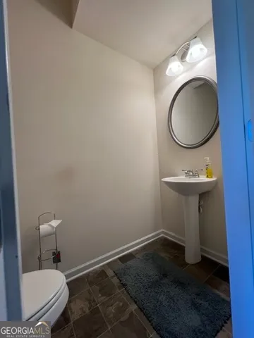 a bathroom with a toilet a sink and a mirror