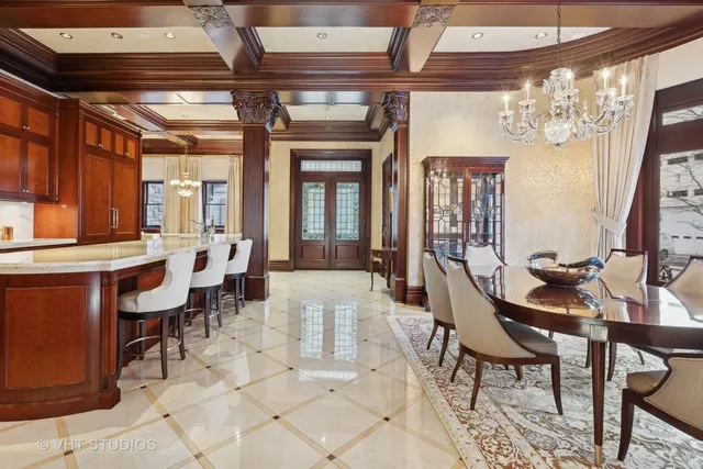 a view of a dining room with furniture a chandelier and a window