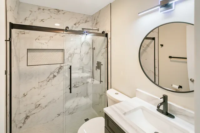 a bathroom with a granite countertop sink toilet and shower