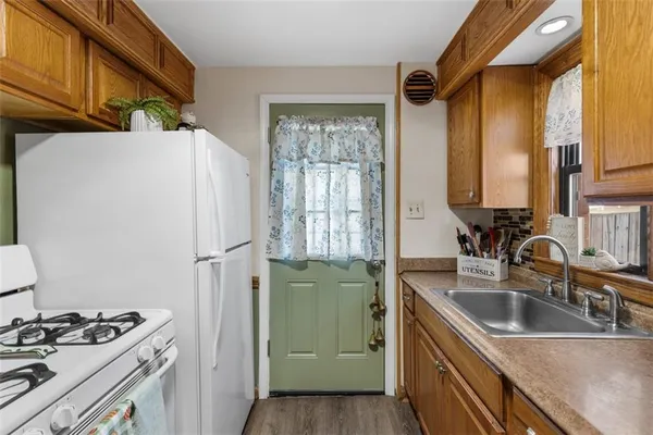 a kitchen with stainless steel appliances granite countertop a sink a refrigerator and a stove
