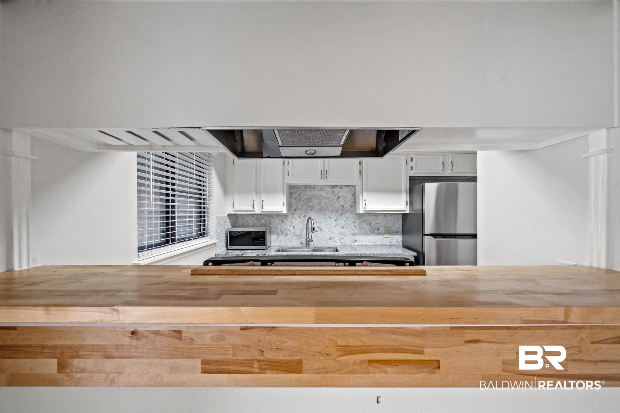 2901 Grant Street, Unit 802 Mobile, AL 36606 - Photo 28 of 37 Kitchen with appliances with stainless steel finishes, sink, backsplash, butcher block counters, and white cabinetry