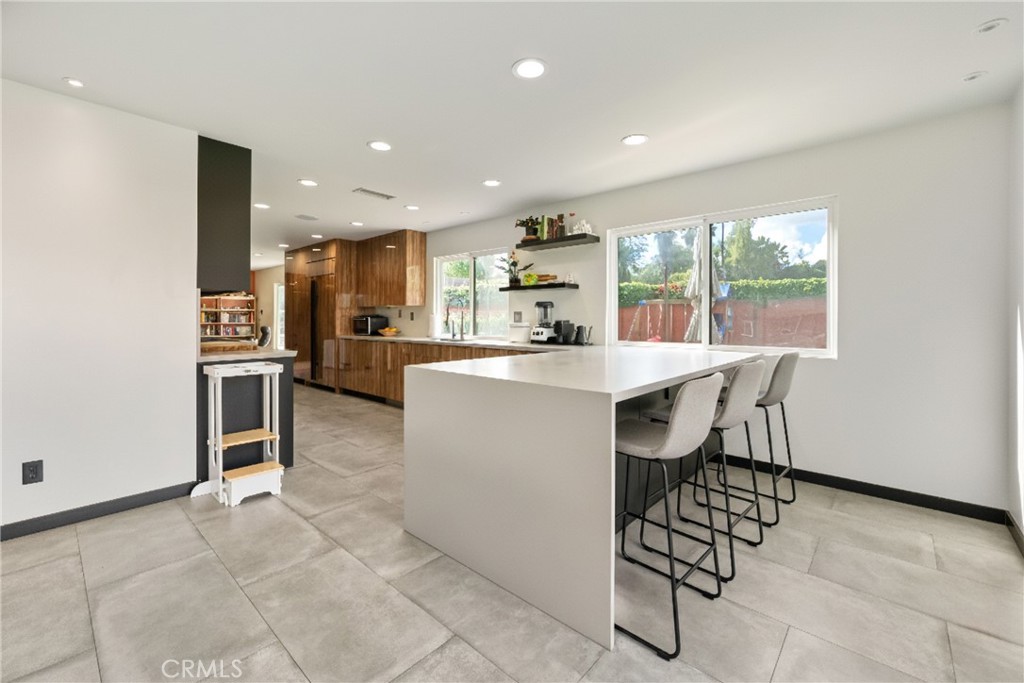 5363 Cornwall Avenue Riverside, CA 92506 - Photo 5 of 23 a kitchen with stainless steel appliances granite countertop a sink a stove a refrigerator a microwave oven with white cabinets and wooden floor
