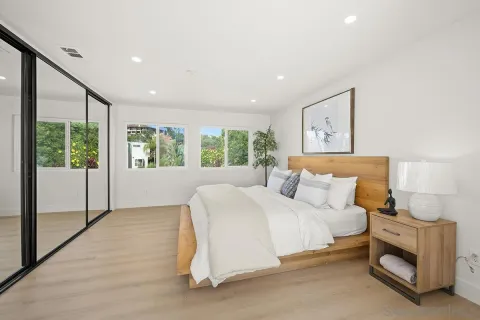 a bedroom with a large bed and a potted plant