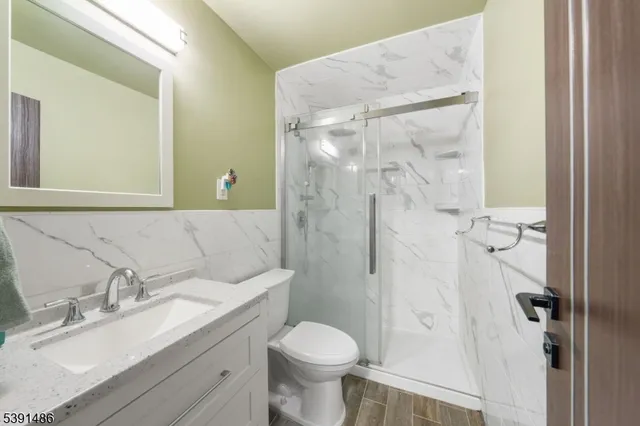a bathroom with a granite countertop toilet sink and shower