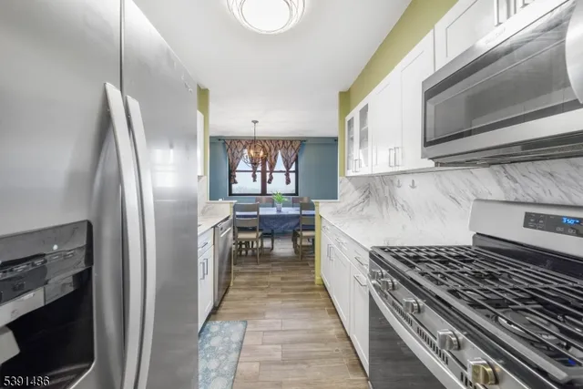 a kitchen with stainless steel appliances granite countertop a refrigerator and a stove top oven