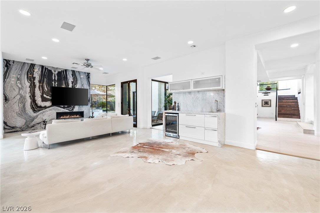 2000 Grouse Street Las Vegas, NV 89134 - Photo 18 of 89 A striking marble feature wall with a linear fireplace anchors this elegant living space, complemented by a convenient wet bar.