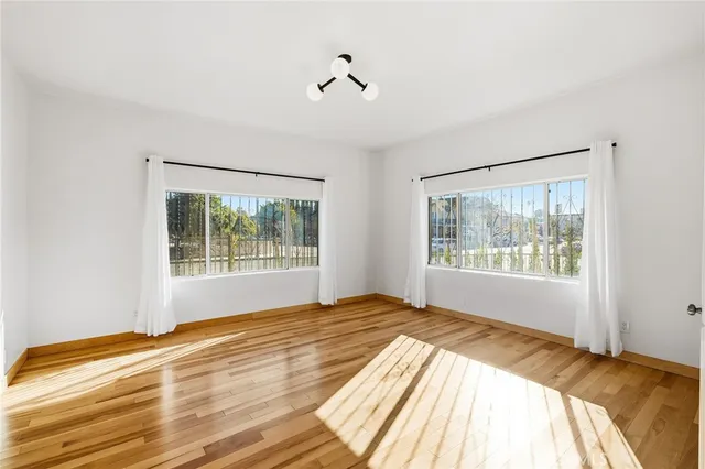 a view of a bedroom with wooden floor and a window