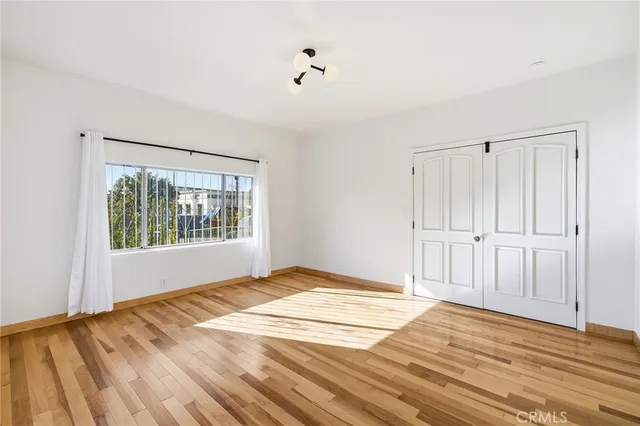a view of a bedroom with wooden floor and front door