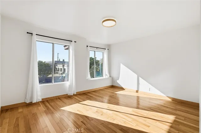 a view of a bedroom with wooden floor and a window