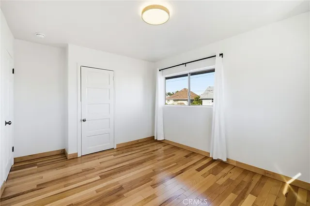 an empty room with window and wooden floor