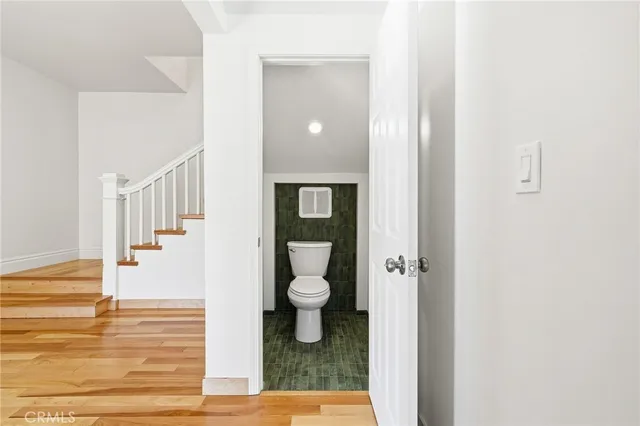 a view of a hallway with toilet and entryway