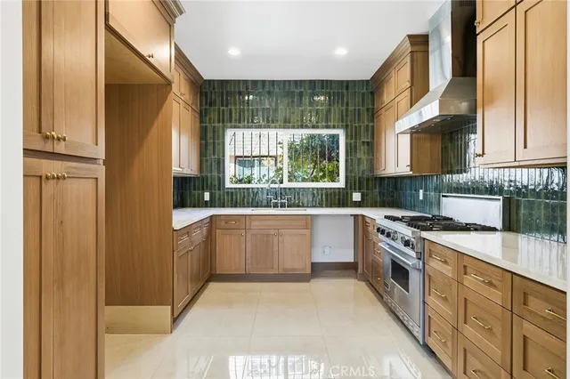 a kitchen with stainless steel appliances granite countertop a stove a sink and a refrigerator