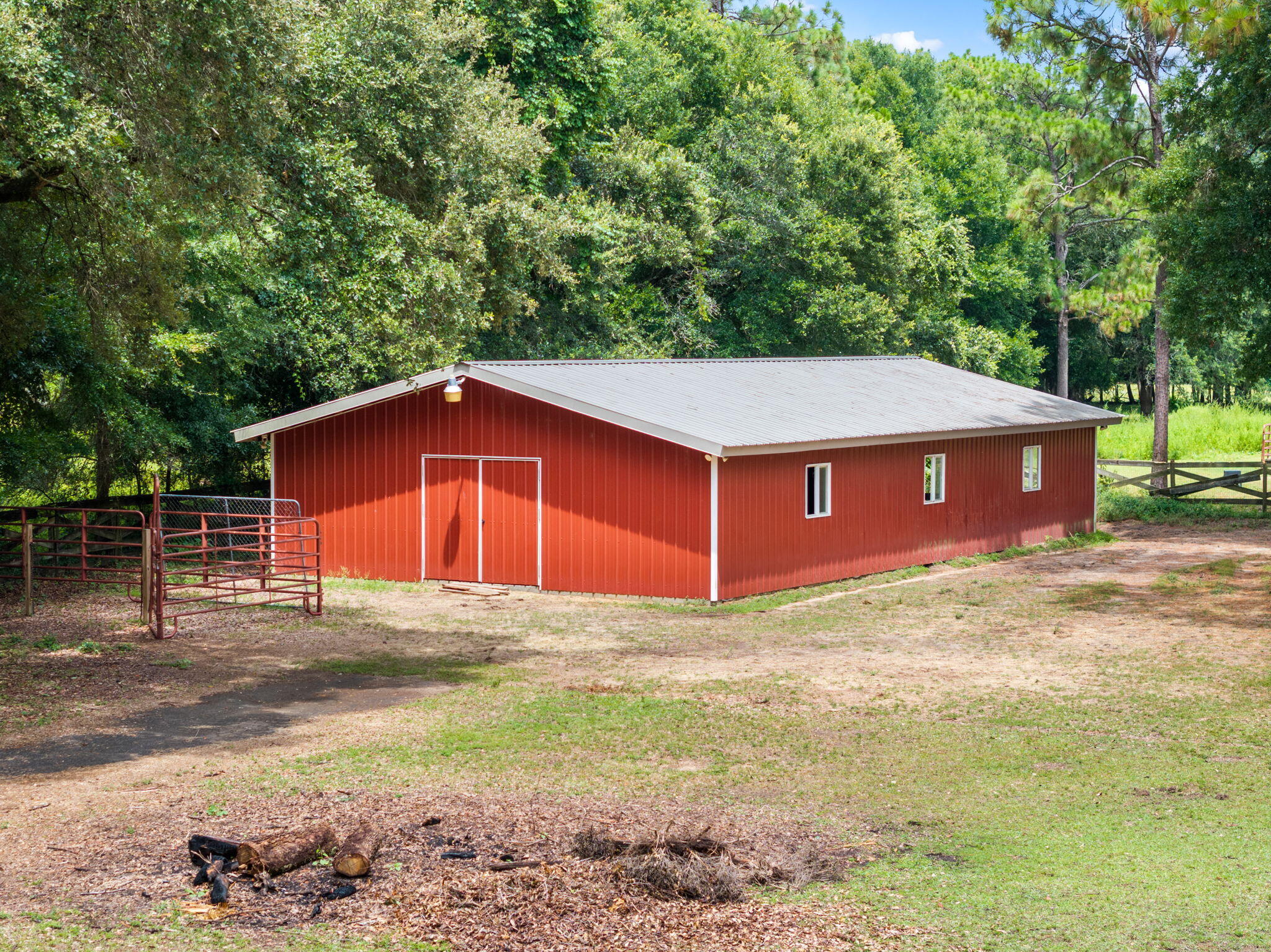 5750 Windham Road Milton, FL 32570 - Photo 66 of 77 a backyard of a house with large trees and a wooden fence