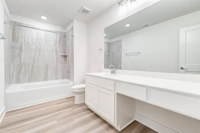 a bathroom with a double vanity sink toilet mirror and bathtub