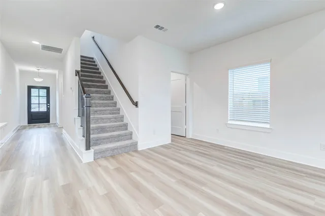 a view of a room with a wooden floor and stairs