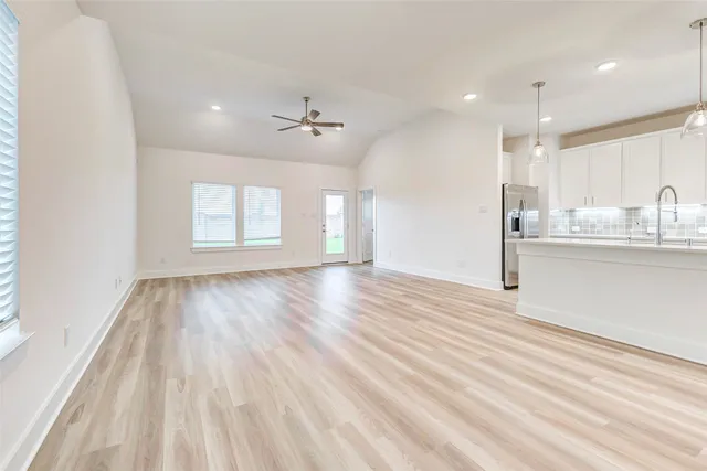 a view of an empty room with a kitchen
