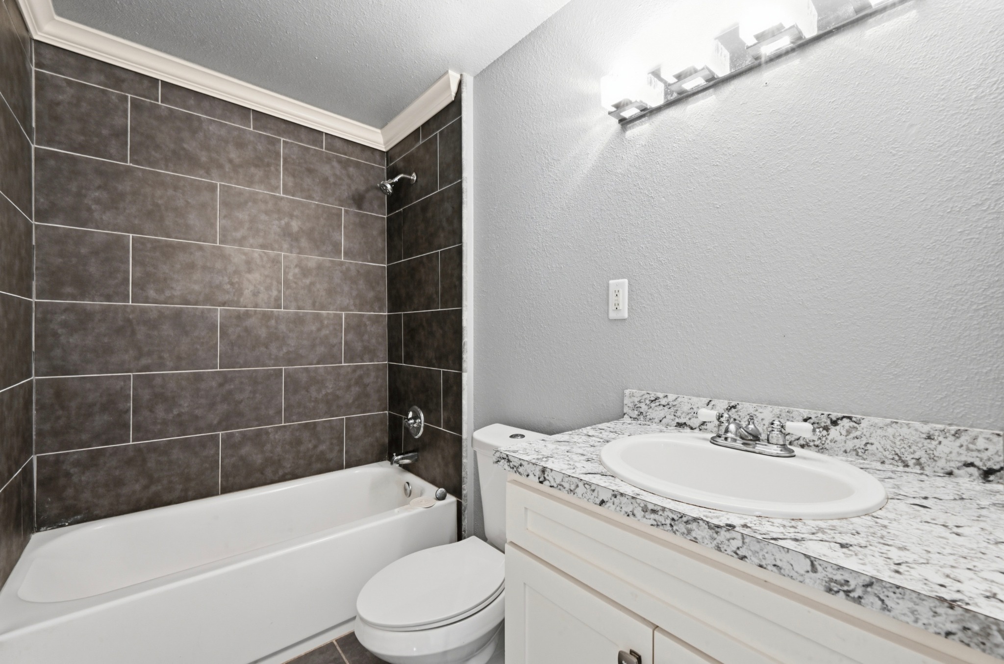 1127 Parr Street Luling, TX 78648 - Photo 15 of 20 A refined bathroom featuring a clean tub, sleek tiling, and a crisp white vanity.