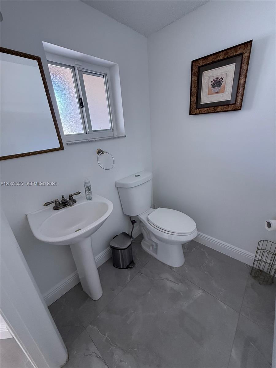 203 Riviera Circle, Unit 203 Weston, FL 33326 - Photo 14 of 30 a white toilet sitting next to a bathroom sink