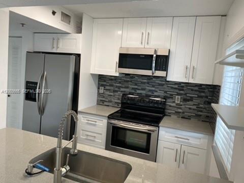 203 Riviera Circle, Unit 203 Weston, FL 33326 - Photo 5 of 30 a kitchen with granite countertop a stove and a refrigerator