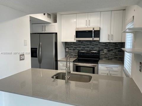 203 Riviera Circle, Unit 203 Weston, FL 33326 - Photo 6 of 30 a kitchen with granite countertop a refrigerator and a stove