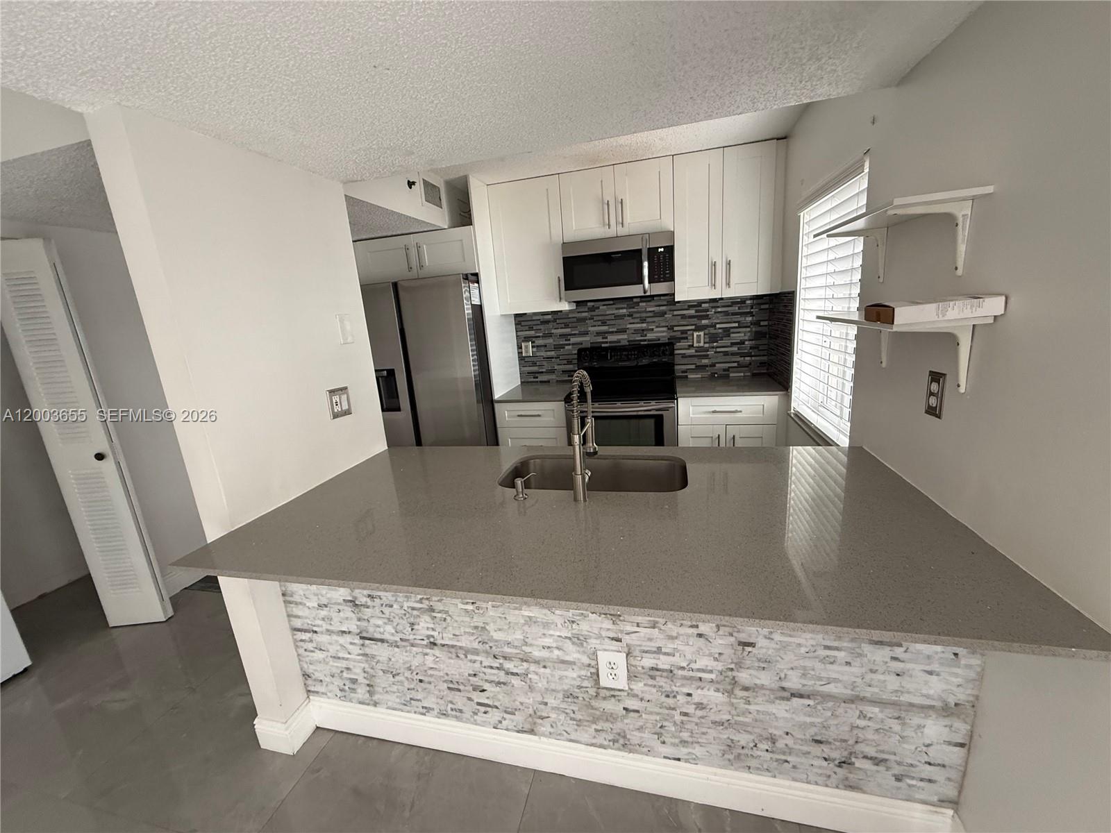 203 Riviera Circle, Unit 203 Weston, FL 33326 - Photo 9 of 30 a view of kitchen with sink microwave and refrigerator
