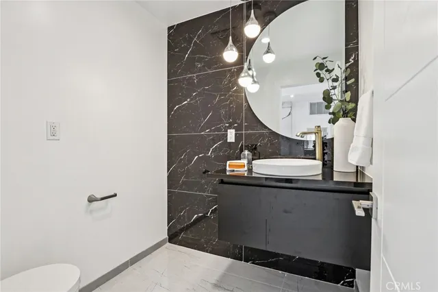 a bathroom with a sink mirror and toilet