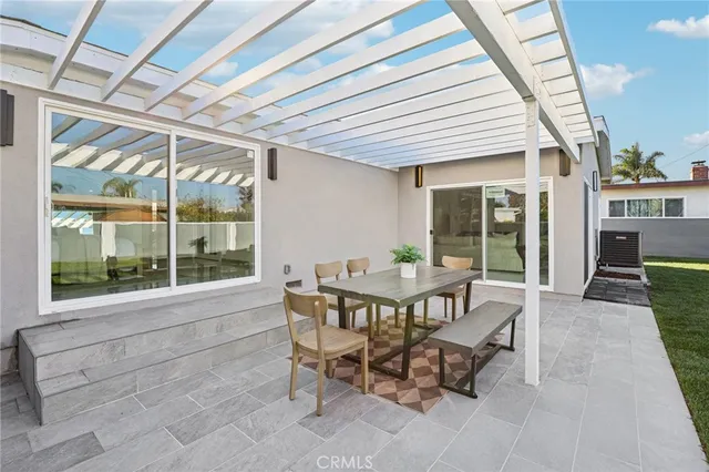a view of a patio with table and chairs with wooden floor and fence