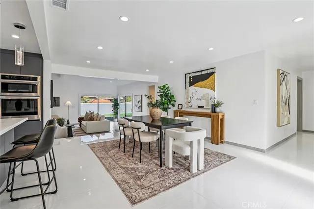 a living room with furniture a rug and a dining table