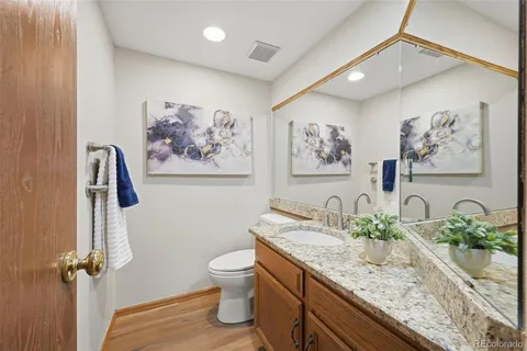 a bathroom with a granite countertop sink a toilet and a shower