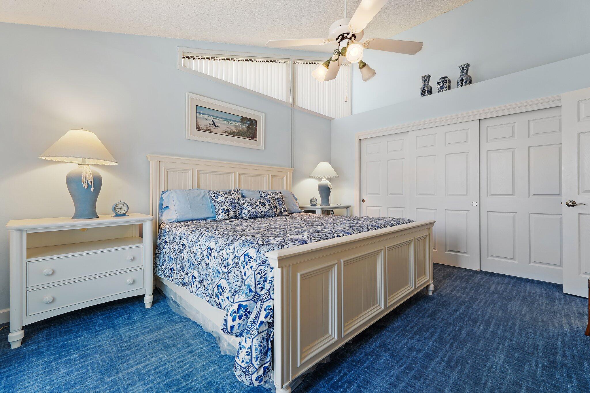 1801 South Us Highway, Unit 8D Jupiter, FL 33477 - Photo 14 of 36 a bedroom with a bed and a chandelier