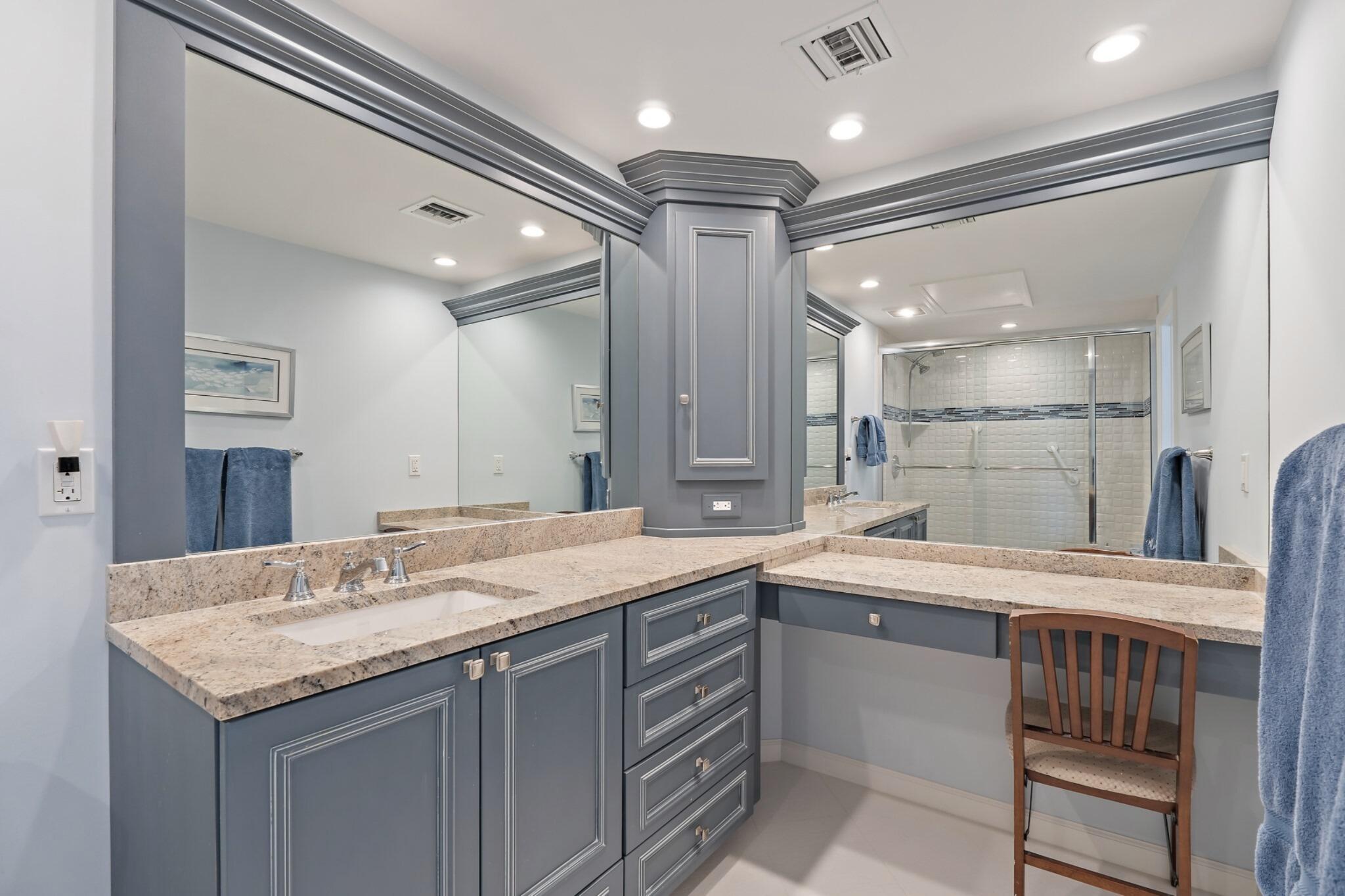 1801 South Us Highway, Unit 8D Jupiter, FL 33477 - Photo 16 of 36 a bathroom with a granite countertop sink a large mirror and a shower