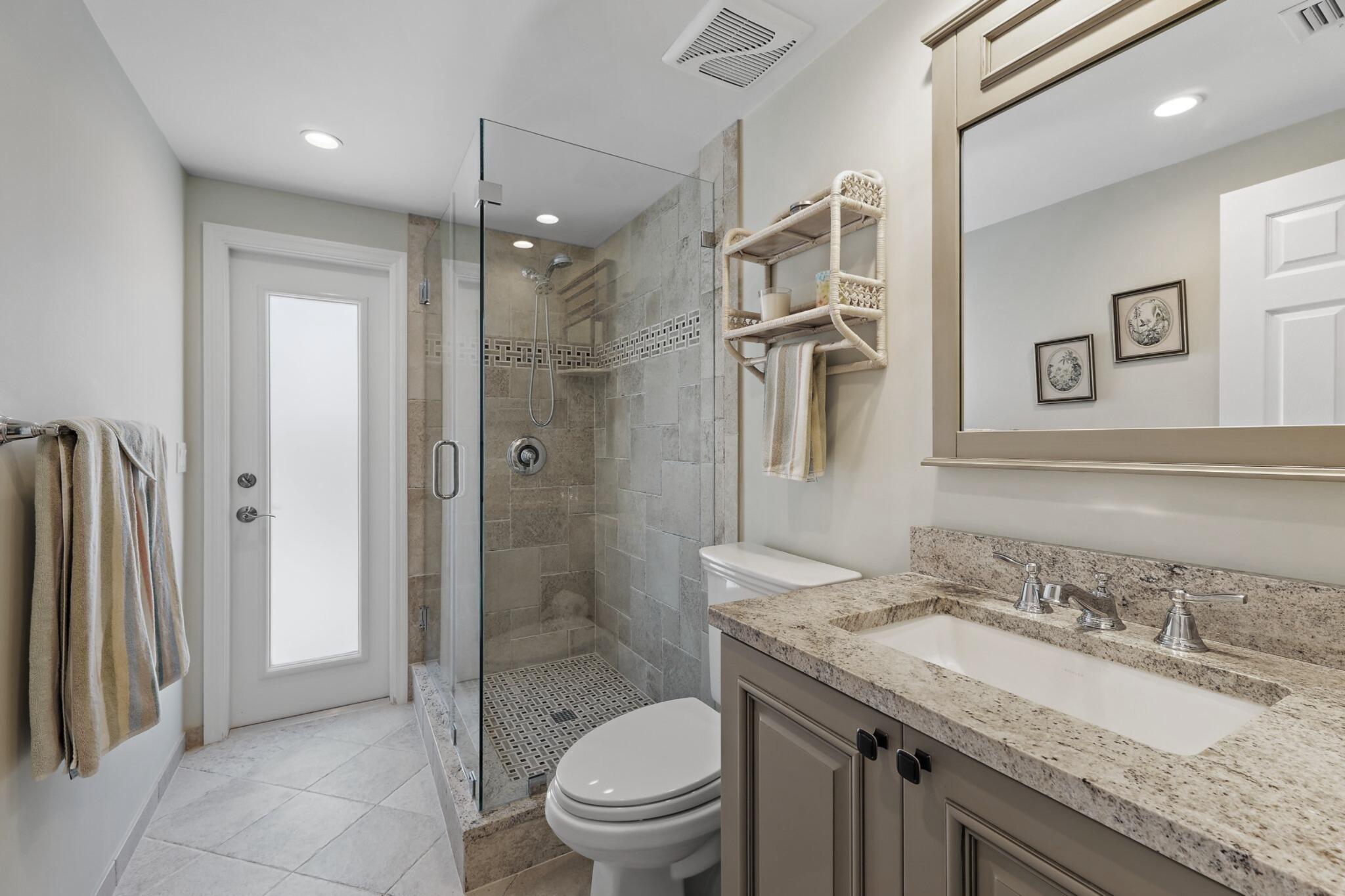 1801 South Us Highway, Unit 8D Jupiter, FL 33477 - Photo 21 of 36 a bathroom with a granite countertop sink toilet and shower