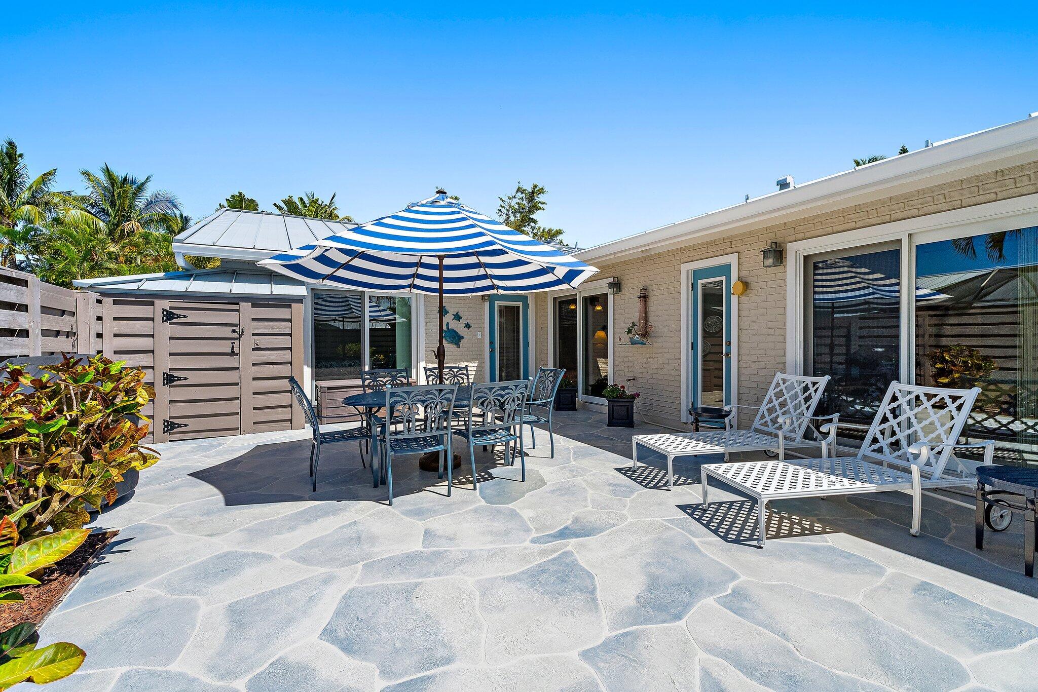 1801 South Us Highway, Unit 8D Jupiter, FL 33477 - Photo 5 of 36 a view of a patio with table and chairs potted plants and floor to ceiling window