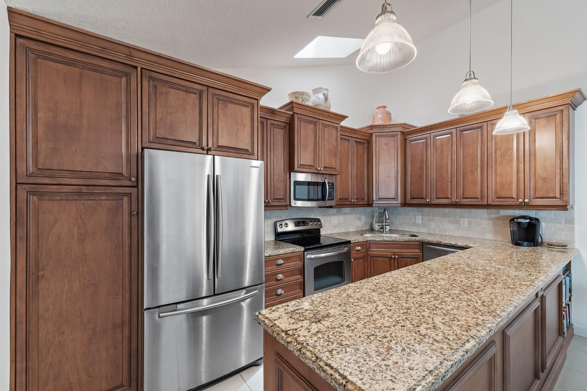 1801 South Us Highway, Unit 8D Jupiter, FL 33477 - Photo 7 of 36 a kitchen with granite countertop stainless steel appliances a refrigerator and a sink