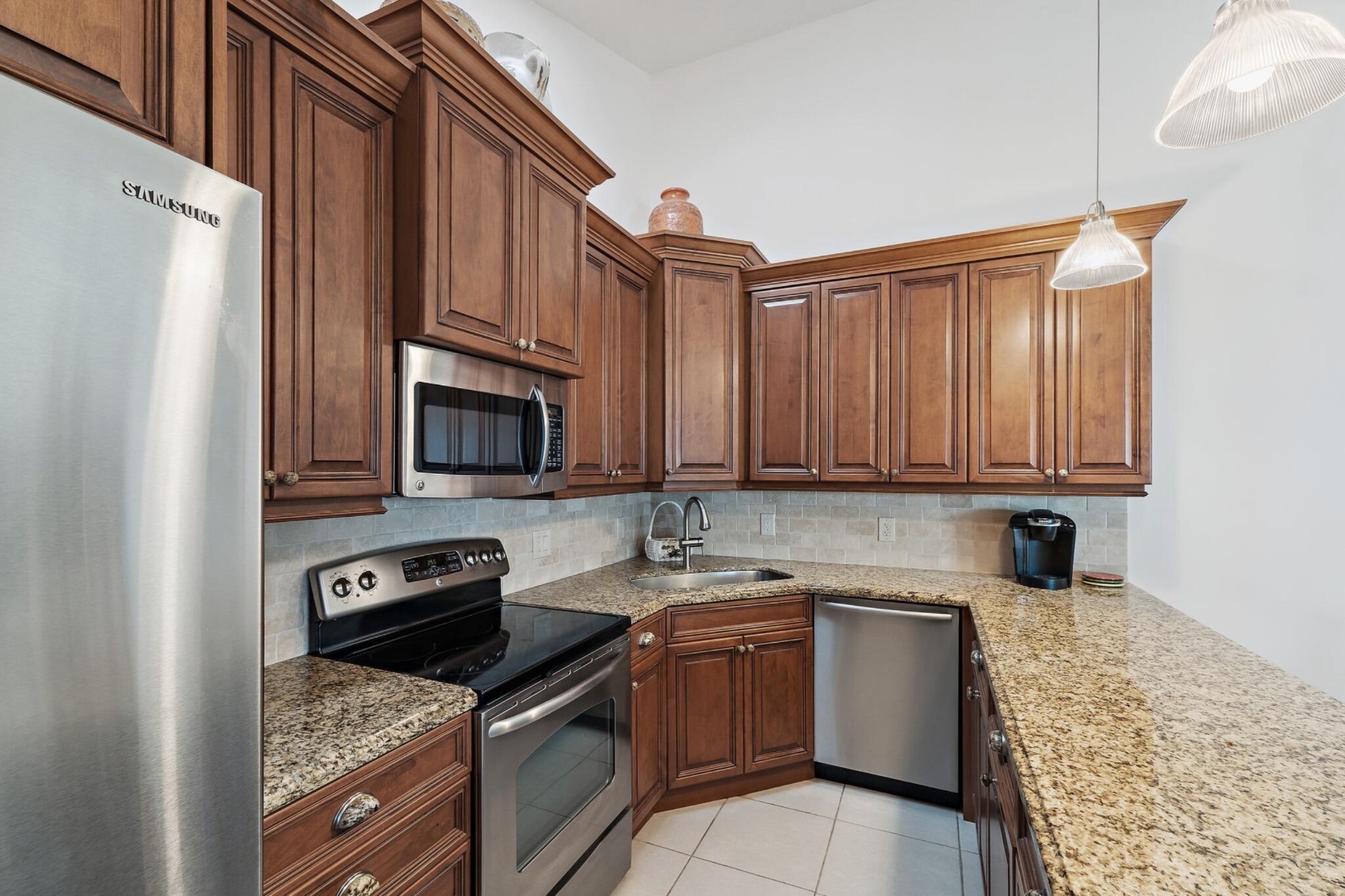 1801 South Us Highway, Unit 8D Jupiter, FL 33477 - Photo 8 of 36 a kitchen with a refrigerator stove top oven and sink