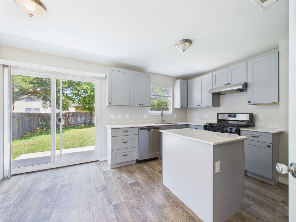 4004 Reeders Drive Austin, TX 78725 - Photo 1 of 1 a kitchen with a stove a sink and a refrigerator