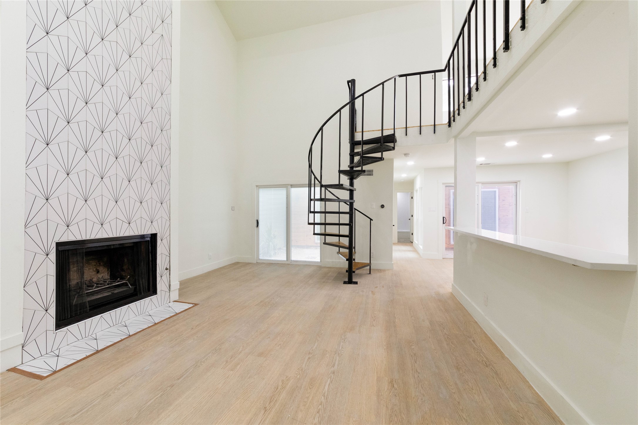 8807 Merion Circle Austin, TX 78754 - Photo 3 of 18 A striking fireplace with a decorative tile surround anchors this living area, featuring a dramatic spiral staircase.