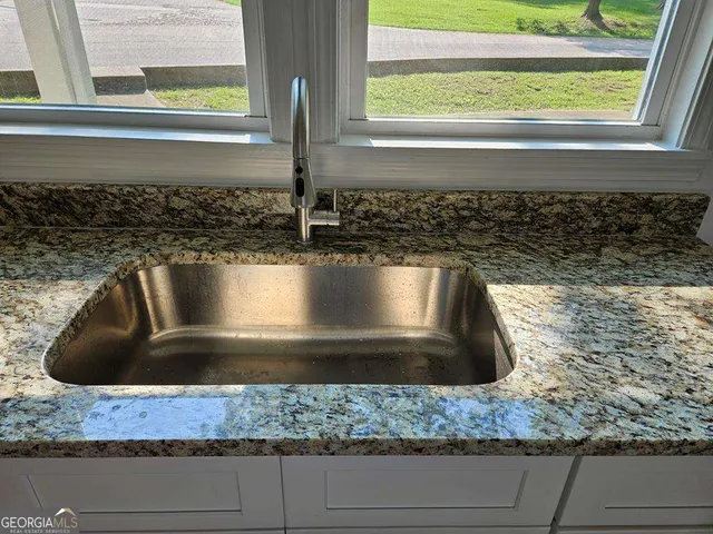 a kitchen with a sink and wooden floor