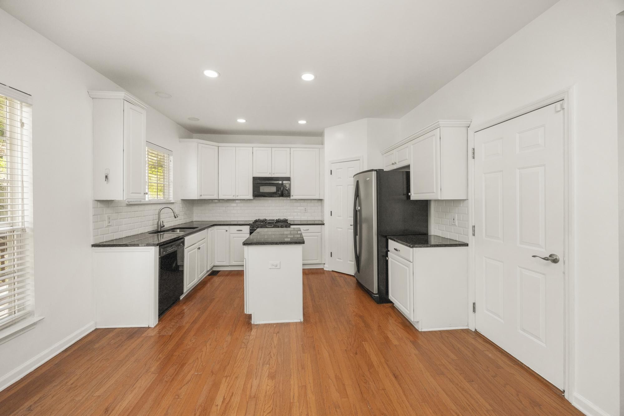 513 Cold Stream Place Nashville, TN 37221 - Photo 14 of 40 a kitchen with a refrigerator a stove top oven a sink dishwasher and a dining table with wooden floor